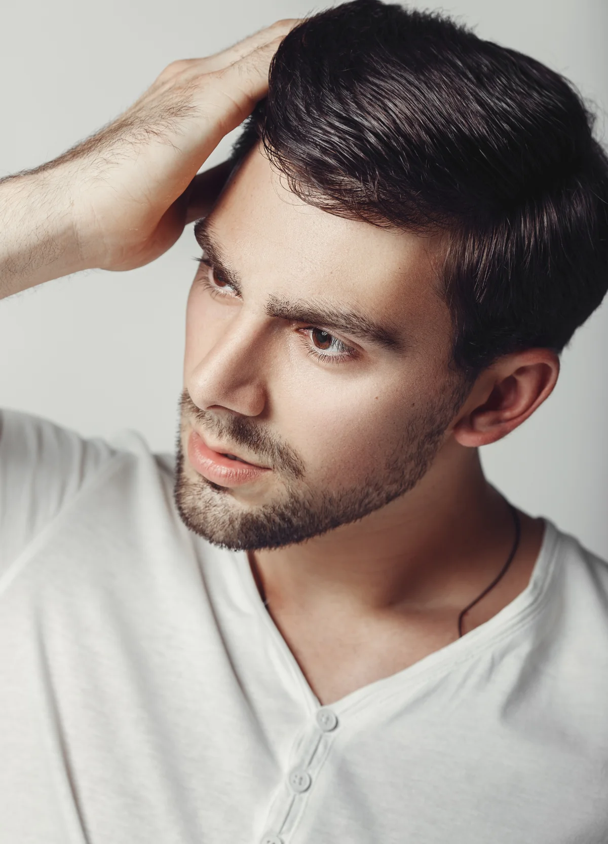 Man with his hand resting on his hair
