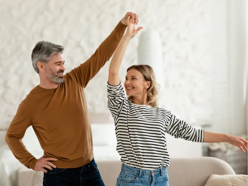Couple dancing at home, feeling energized after Biote hormone therapy